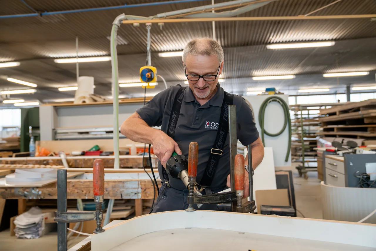 Tischler verpresst einen Radius mit Zwingen